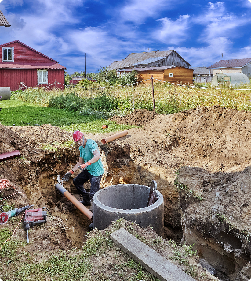 Person working on outdoor pipe installation.