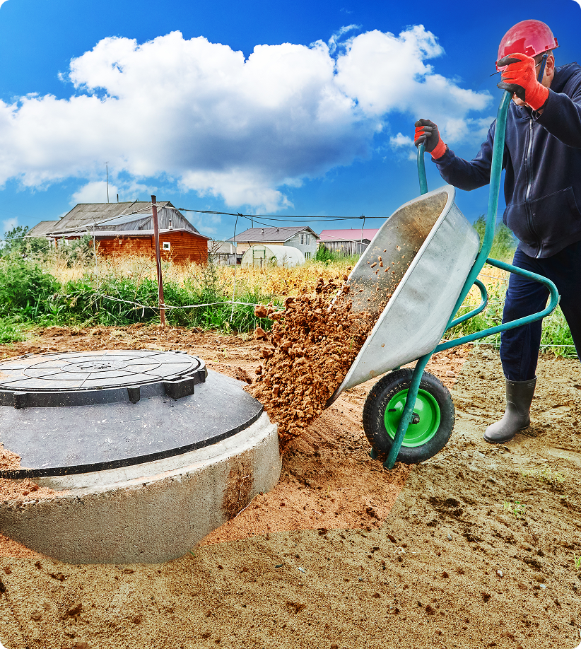 Worker emptying wheelbarrow by septic tank.