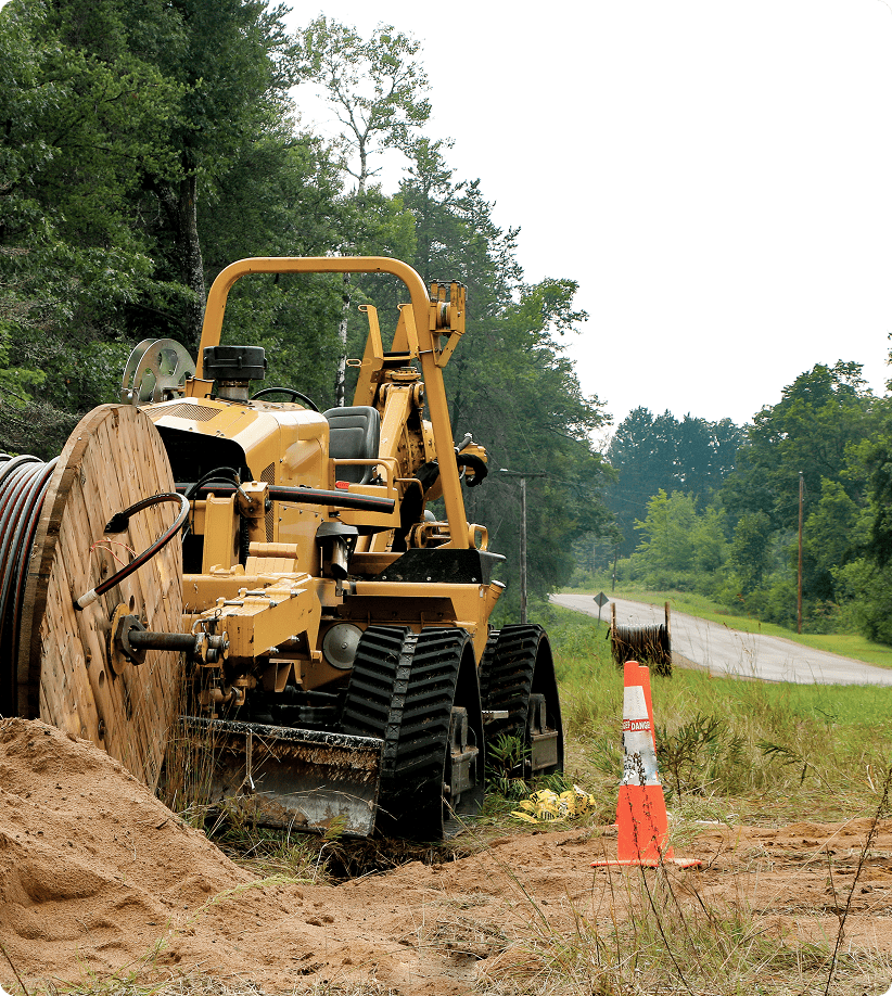 Construction machinery and cable spool near road.